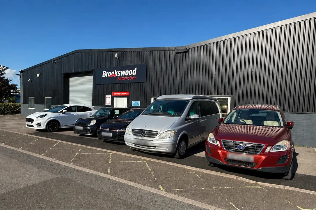A sunny-day lineup of cars looked after by Brookswood Automotive, including a Ford Puma, Mini, Mercedes Vito and Volvo XC60