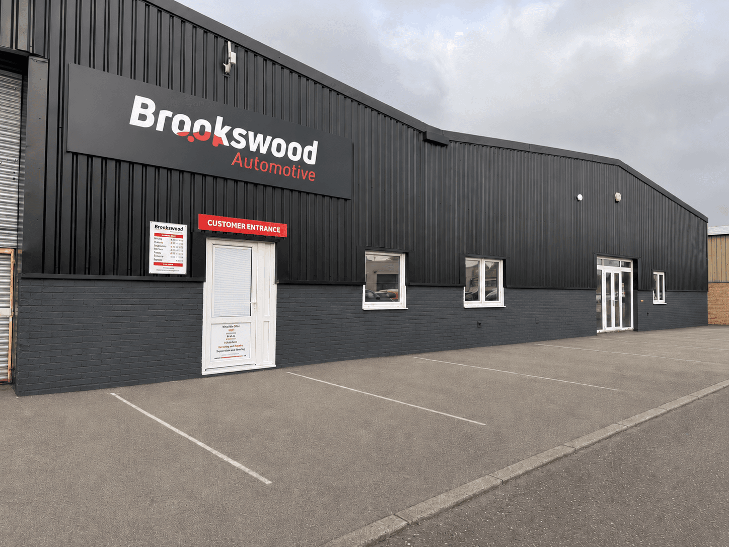 Exterior of the Brookswood Automotive garage in Fareham, with signage, customer entrance and parking